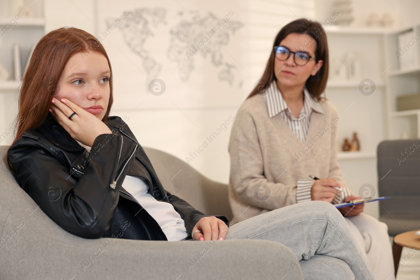 Photo of Psychologist working with difficult teenage girl in office, selective focus