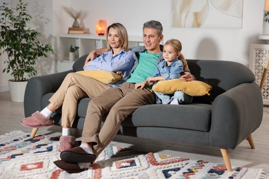 Photo of Family watching TV on sofa at home