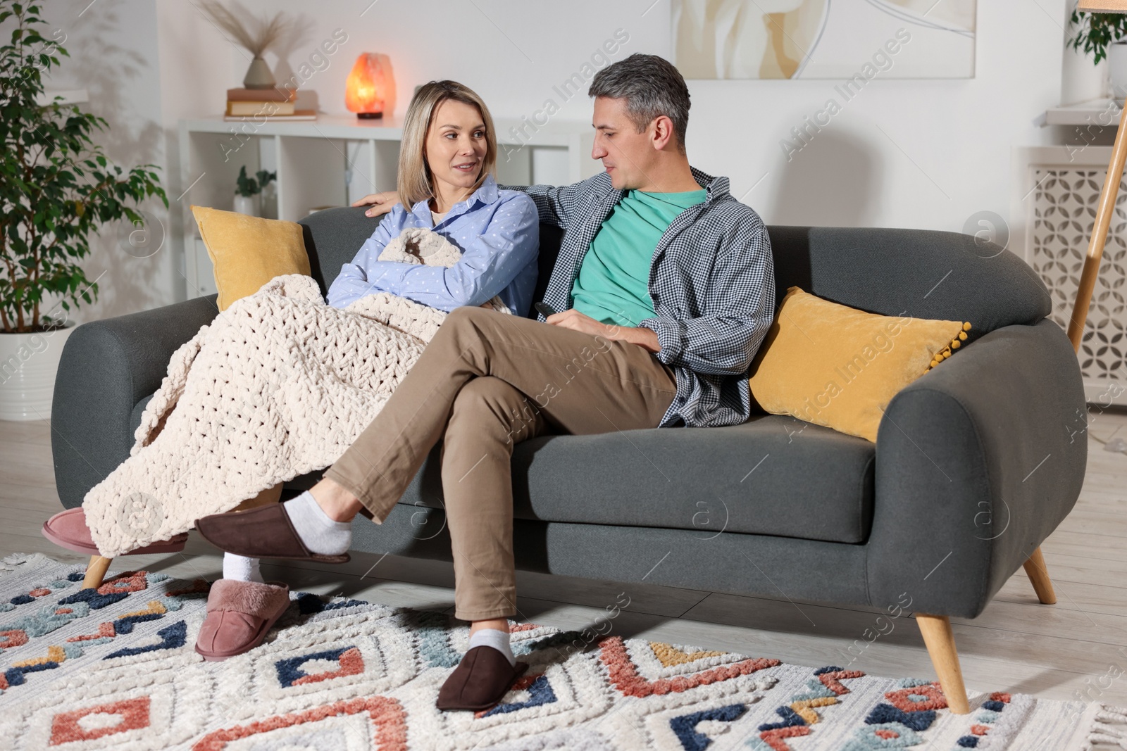 Photo of Lovely couple watching TV on sofa at home