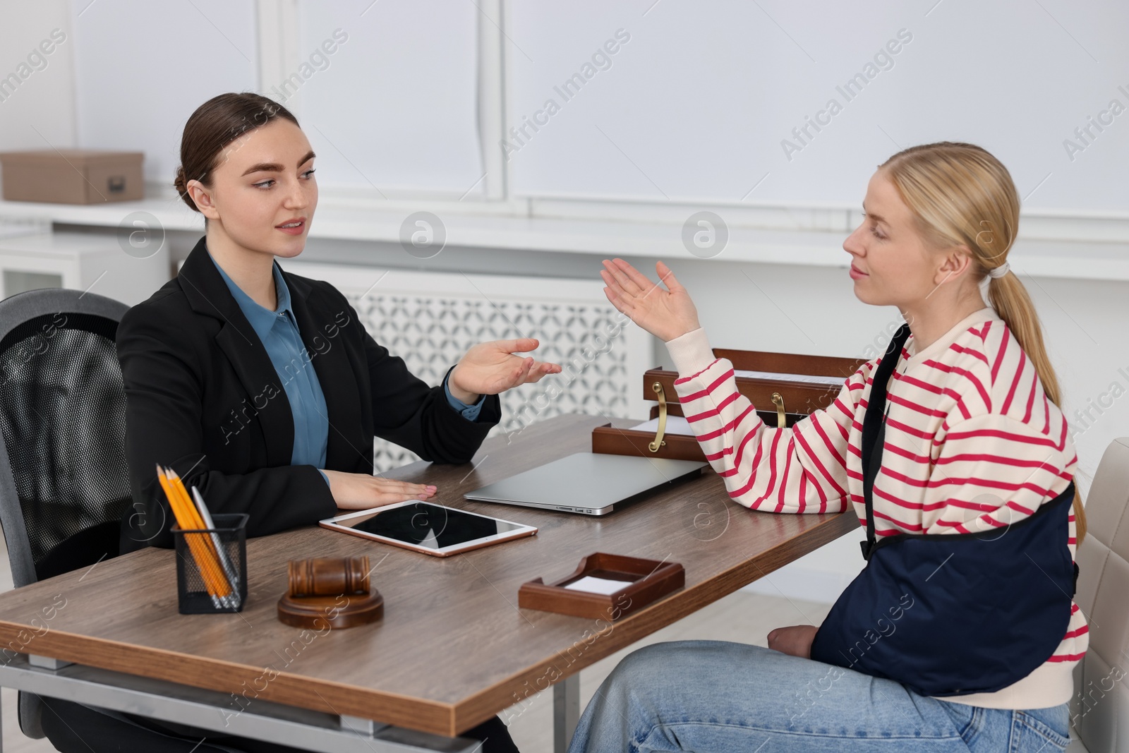 Photo of Injured woman having meeting with lawyer in office