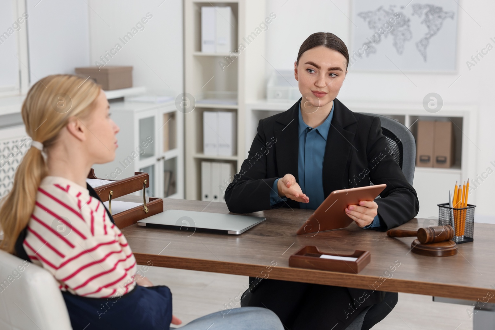 Photo of Injured woman having meeting with lawyer in office, selective focus