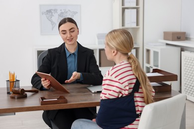 Photo of Injured woman having meeting with lawyer in office, selective focus