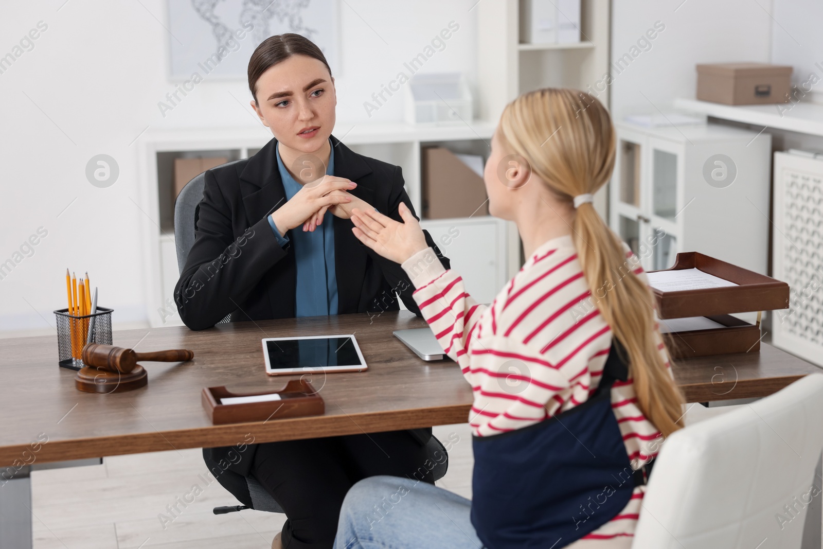 Photo of Injured woman having meeting with lawyer in office, selective focus