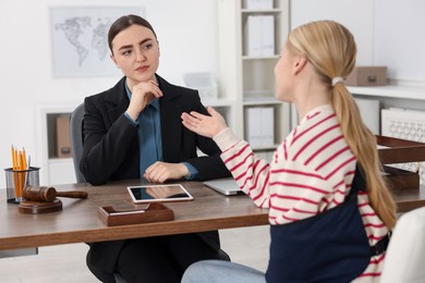 Photo of Injured woman having meeting with lawyer in office, selective focus