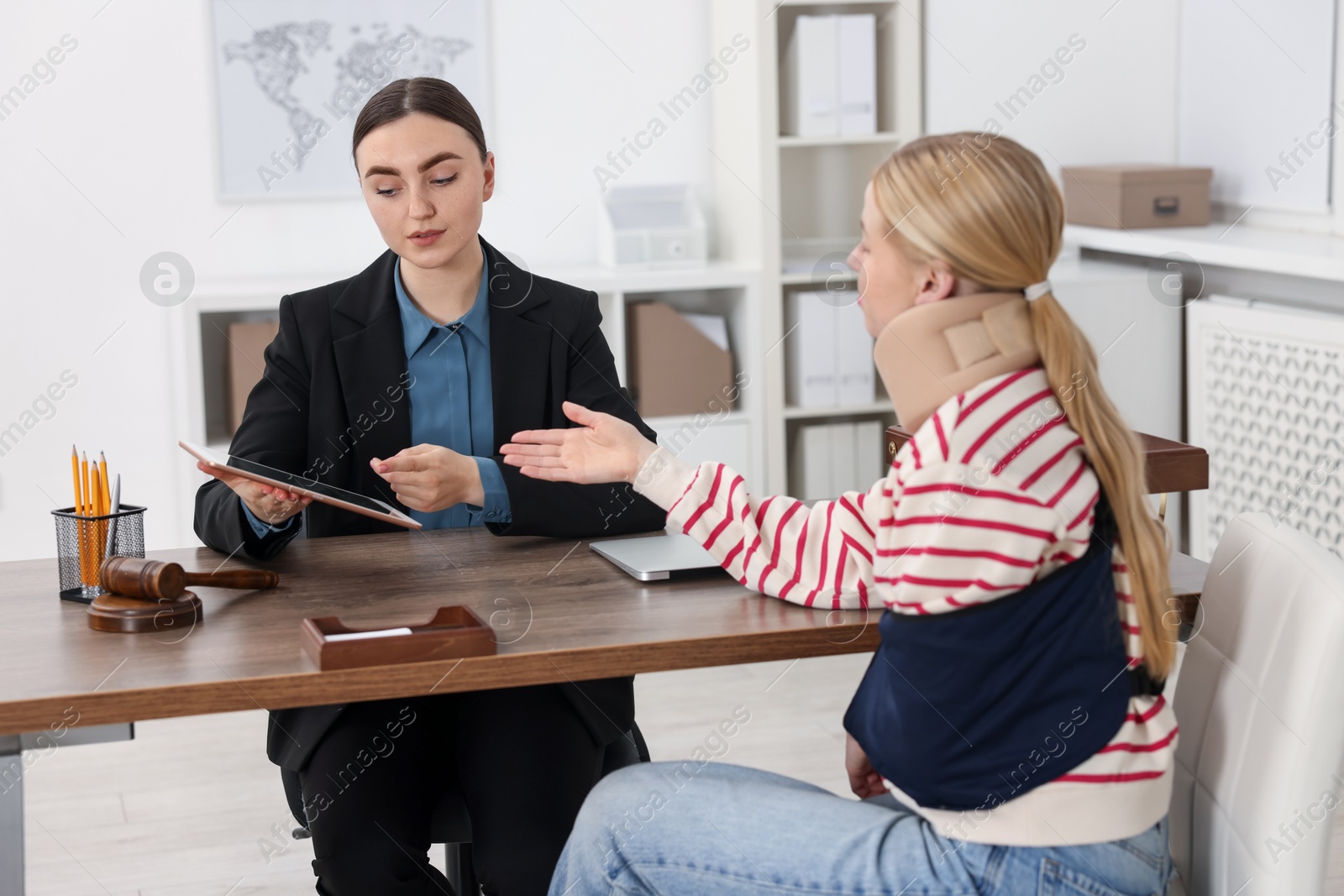 Photo of Injured woman having meeting with lawyer in office, selective focus