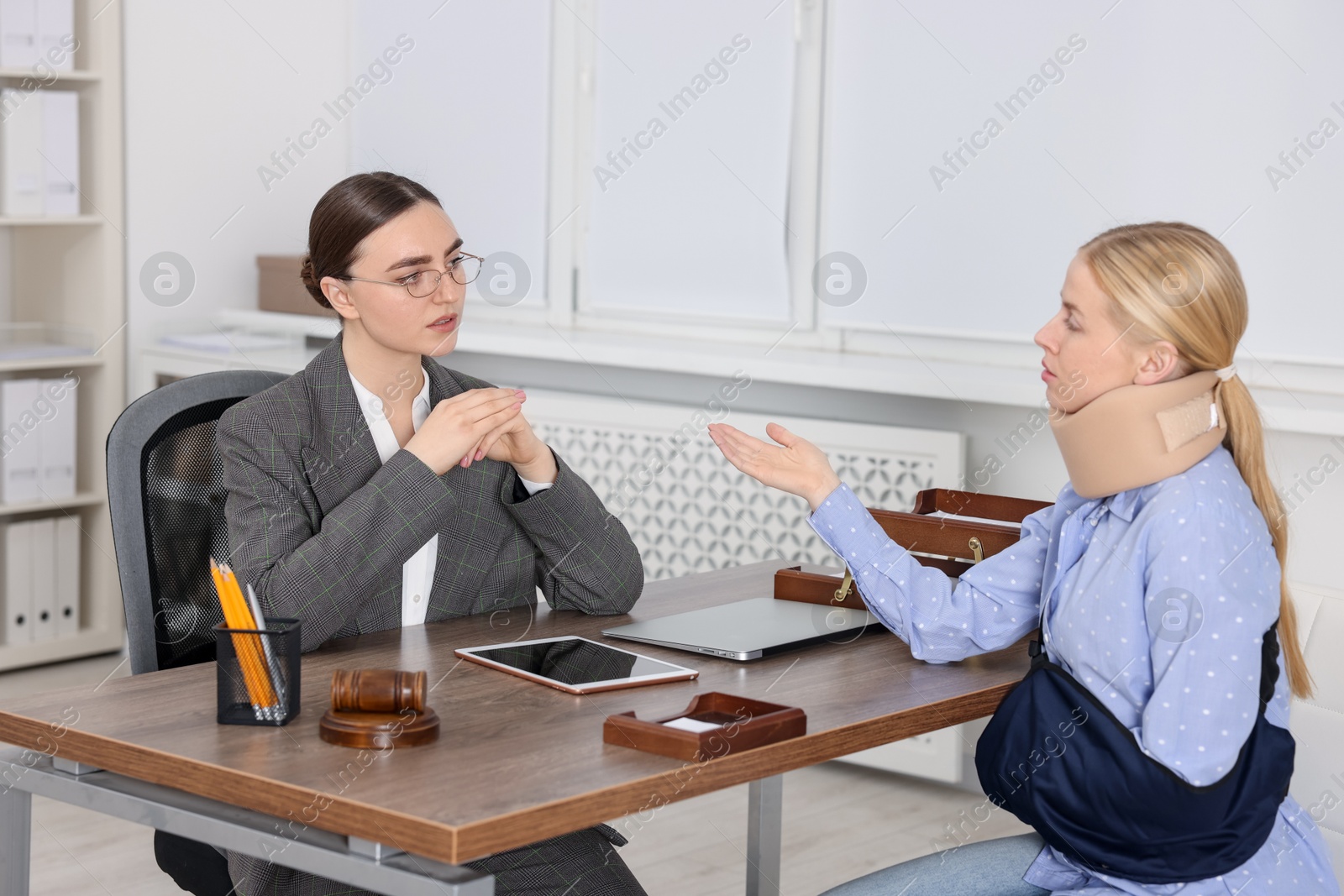 Photo of Injured woman having meeting with lawyer in office