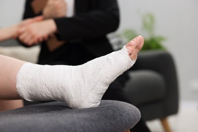 Photo of Injured woman shaking hands with lawyer in office, closeup. Selective focus