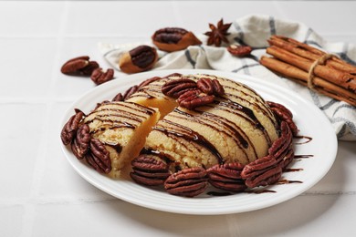 Photo of Delicious sweet semolina halva with pecans on white tiled table, closeup