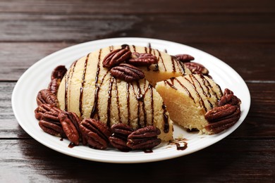 Photo of Delicious sweet semolina halva with pecans on wooden table, closeup