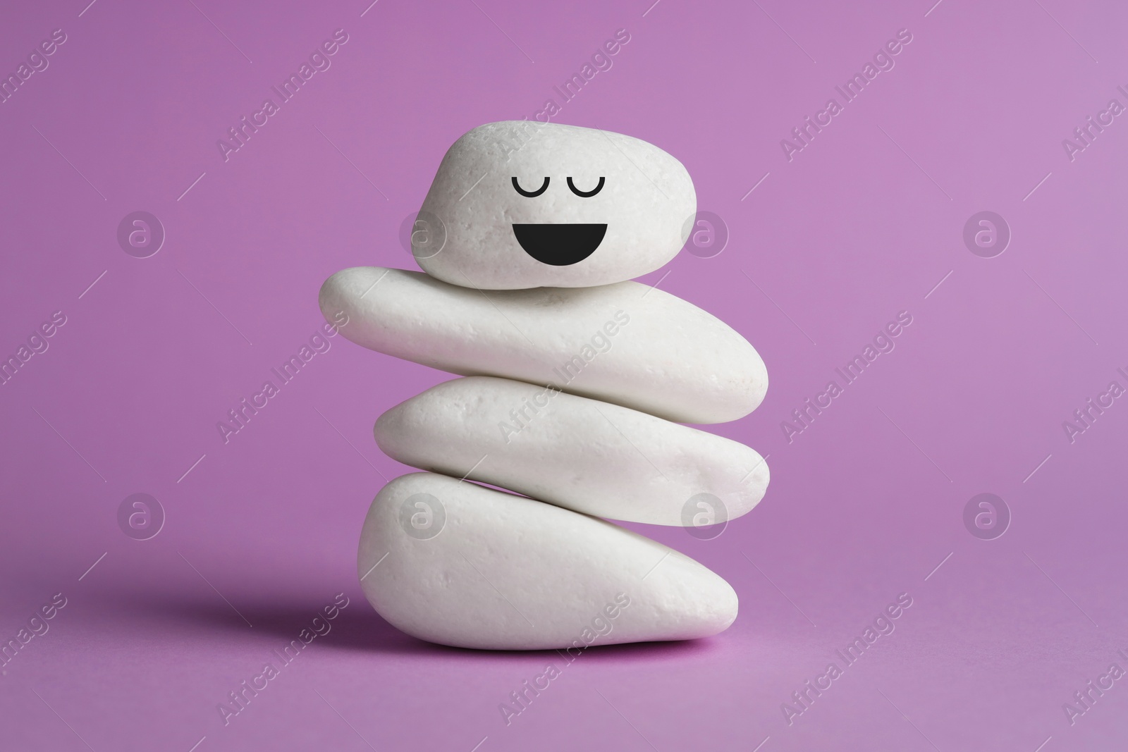 Photo of Stack of rocks on violet background. Harmony and life balance