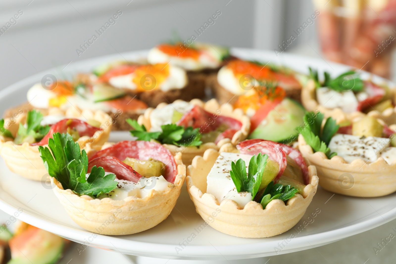 Photo of Many different tasty canapes on stand, closeup