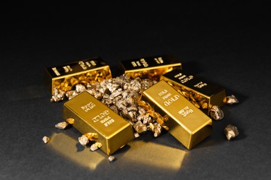 Photo of Gold nuggets and bars on black table