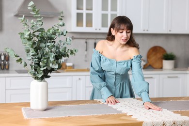 Photo of Woman setting table for dinner at home