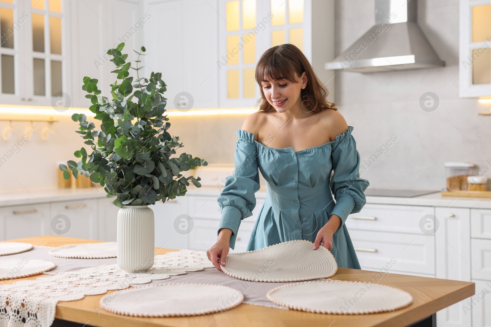 Photo of Woman setting table for dinner at home