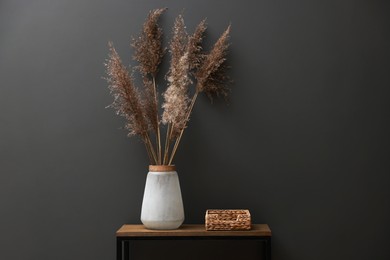 Photo of Console table with decor near grey wall in room. Interior design