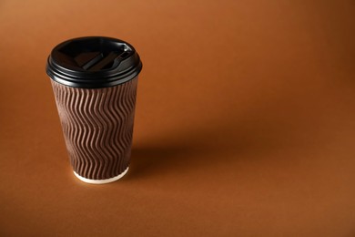 Photo of One paper cup on brown background. Mockup for design