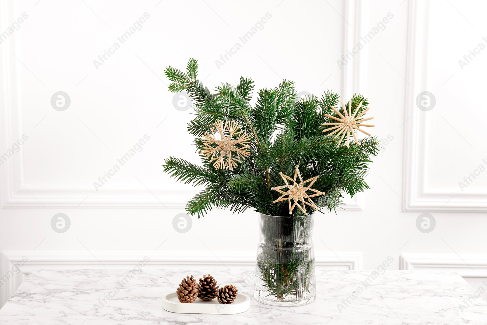 Photo of Beautiful decorated fir tree branches and cones on white table. Christmas season