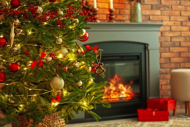 Photo of Beautiful decorated Christmas tree near fireplace at home, closeup. Space for text