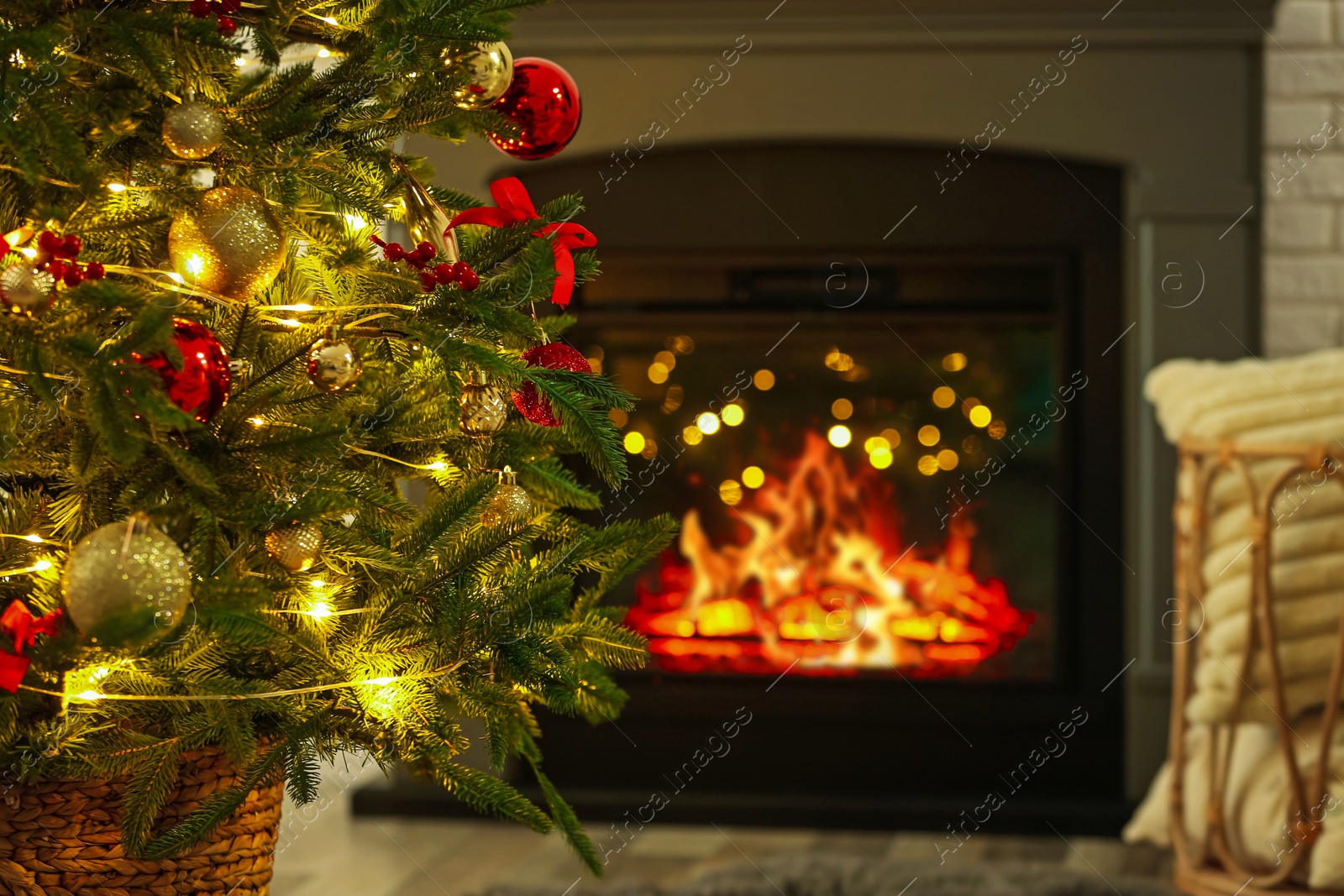 Photo of Beautiful decorated Christmas tree near fireplace at home, closeup. Bokeh effect