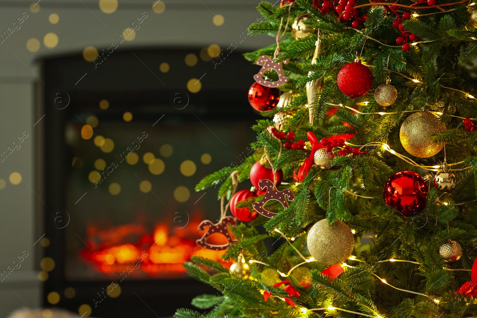 Photo of Beautiful decorated Christmas tree near fireplace at home, closeup. Space for text