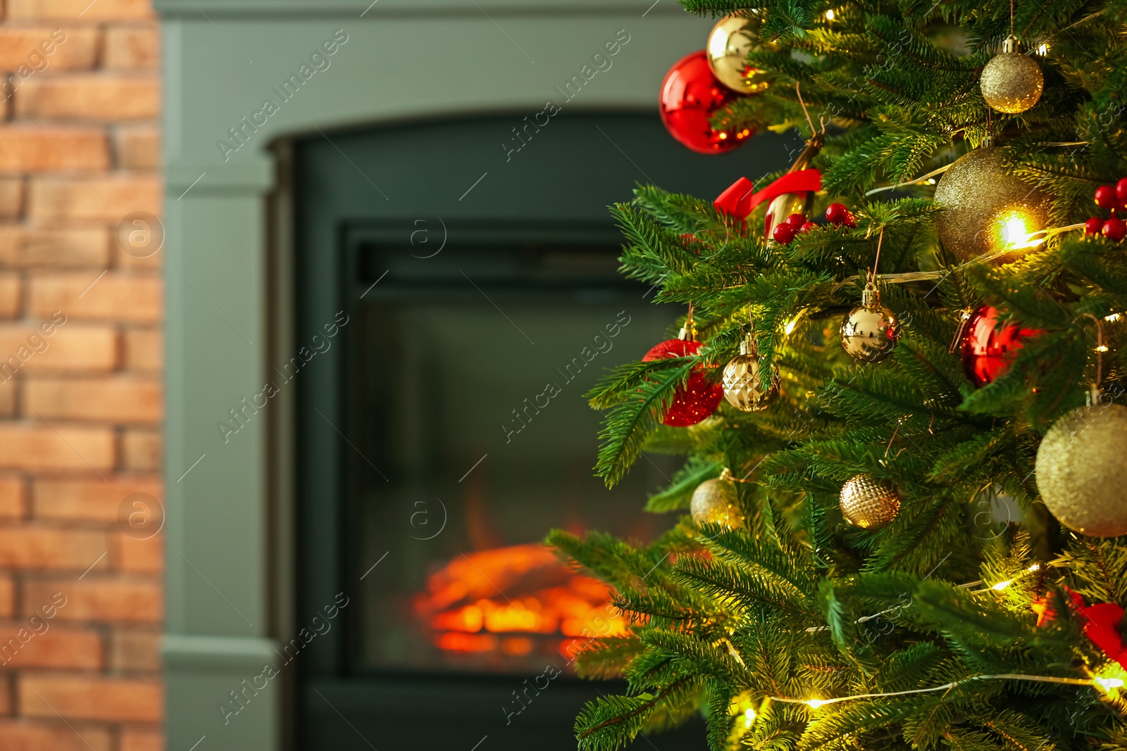 Photo of Beautiful decorated Christmas tree near fireplace at home, closeup. Space for text