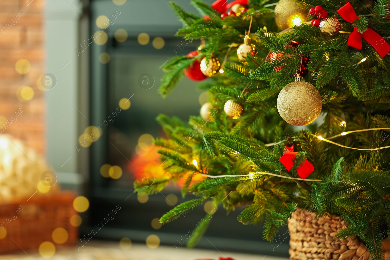 Photo of Beautiful decorated Christmas tree near fireplace at home, closeup. Space for text