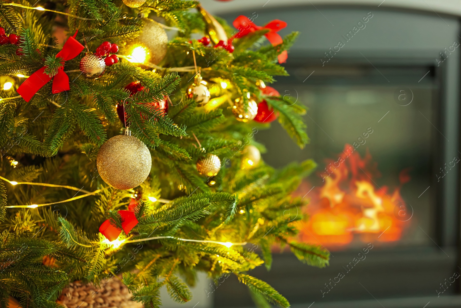 Photo of Beautiful decorated Christmas tree near fireplace at home, closeup. Space for text