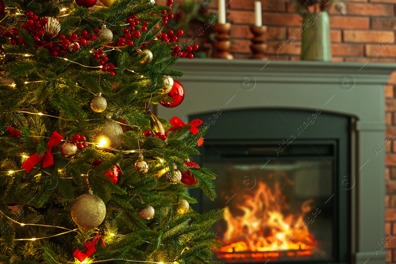 Photo of Beautiful decorated Christmas tree near fireplace at home, closeup. Space for text