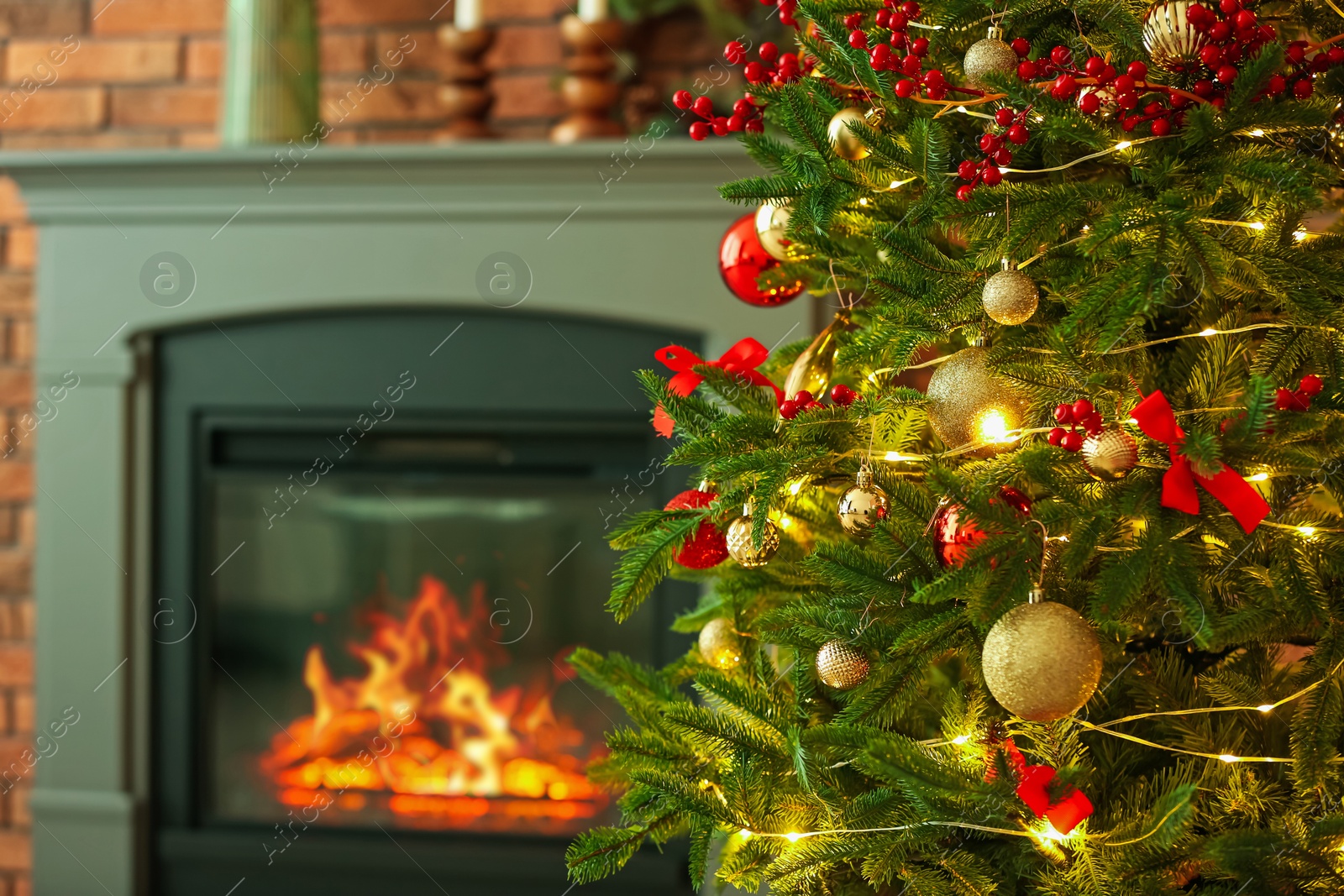 Photo of Beautiful decorated Christmas tree near fireplace at home, closeup. Space for text