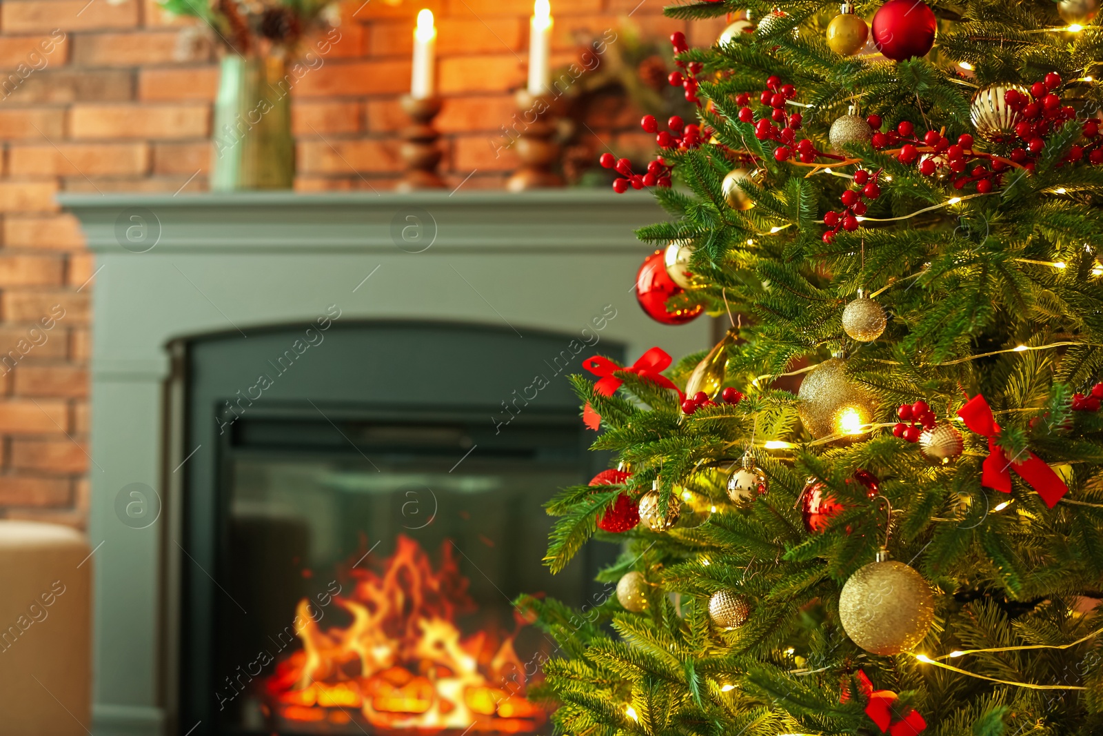 Photo of Beautiful decorated Christmas tree near fireplace at home, closeup. Space for text