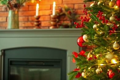 Photo of Beautiful decorated Christmas tree near fireplace at home, closeup. Space for text