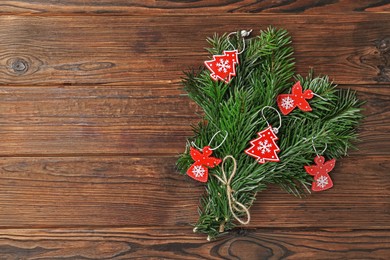 Photo of Festive bouquet of green fir branches with Christmas decor on wooden background, top view. Space for text