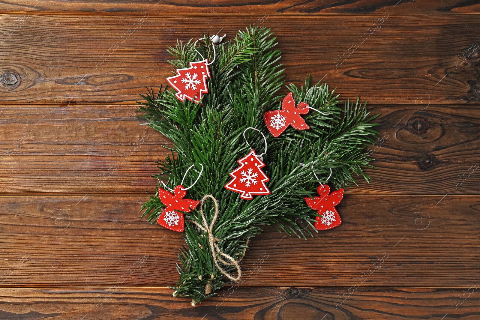 Photo of Festive bouquet of green fir branches with Christmas decor on wooden background, top view