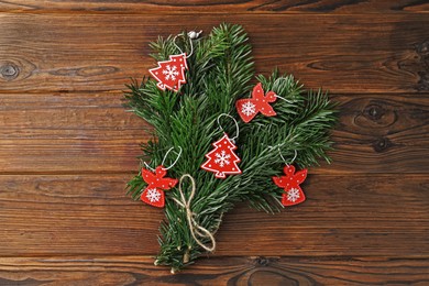 Photo of Festive bouquet of green fir branches with Christmas decor on wooden background, top view