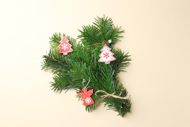 Photo of Festive bouquet of green fir branches with Christmas decor on beige background, top view