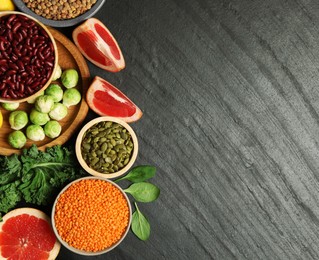 Photo of Different superfood products on black table, flat lay. Space for text