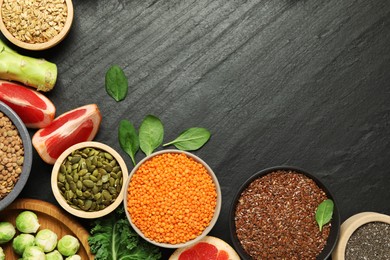 Photo of Different superfood products on black table, flat lay. Space for text