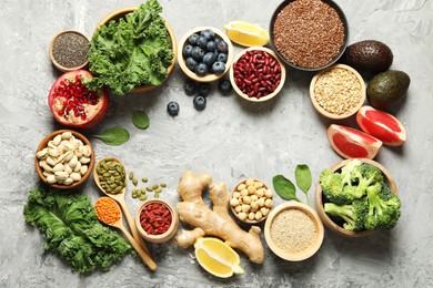 Photo of Frame of different superfood products on grey table, flat lay. Space for text