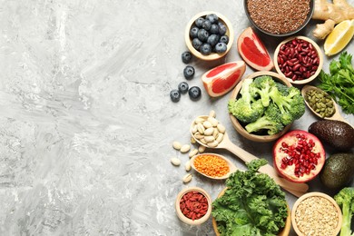 Photo of Different superfood products on grey table, flat lay. Space for text