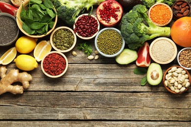 Photo of Different superfood products on wooden table, flat lay. Space for text