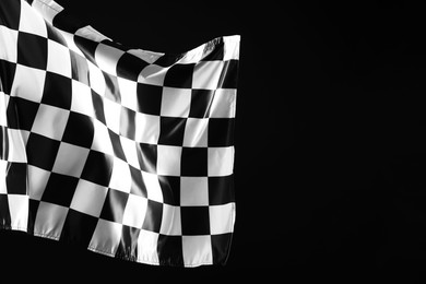 Photo of One racing checkered flag on black background, space for text