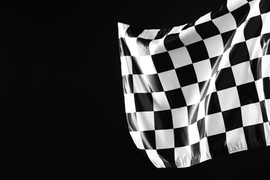 Photo of One racing checkered flag on black background, space for text