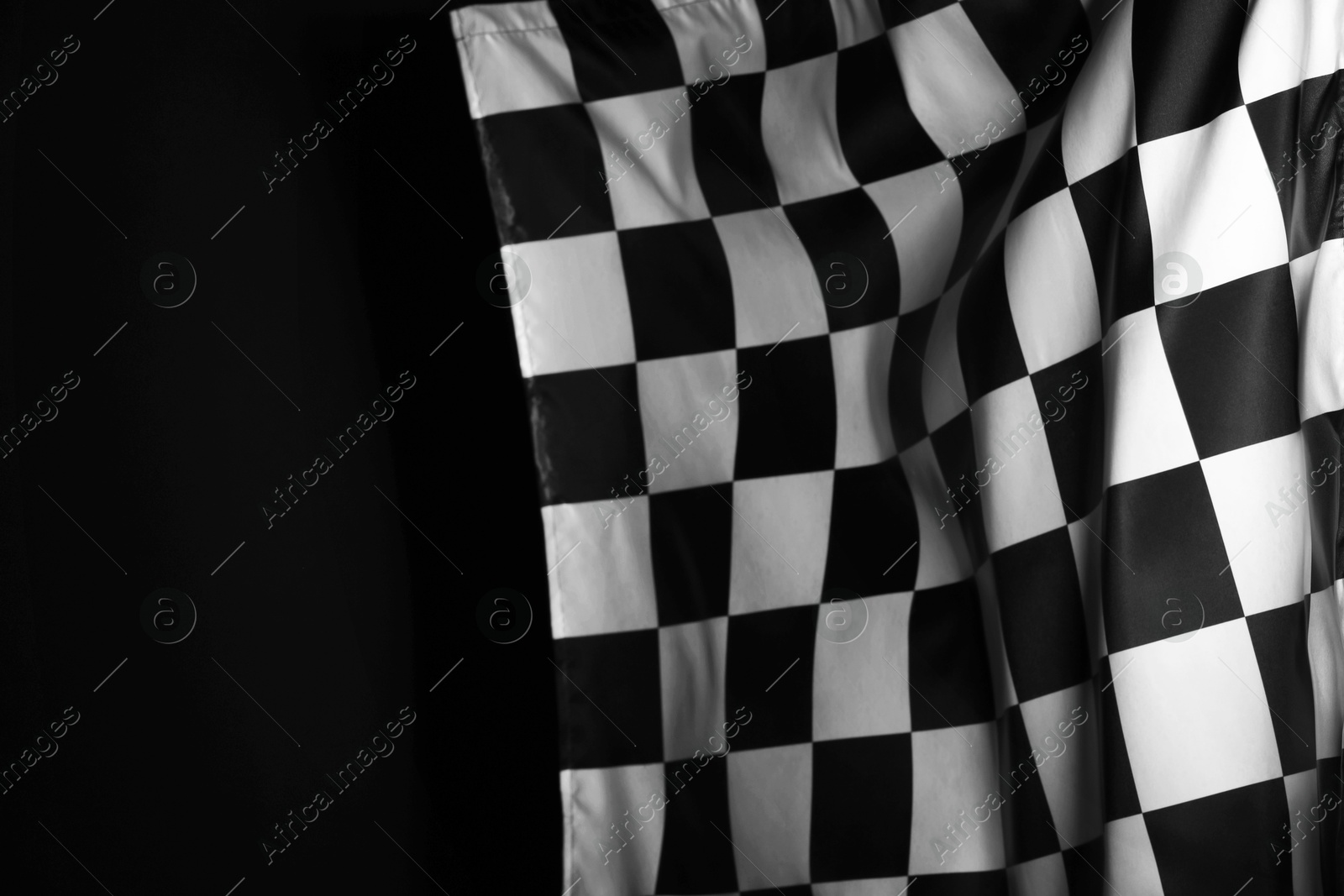 Photo of One racing checkered flag on black background, space for text