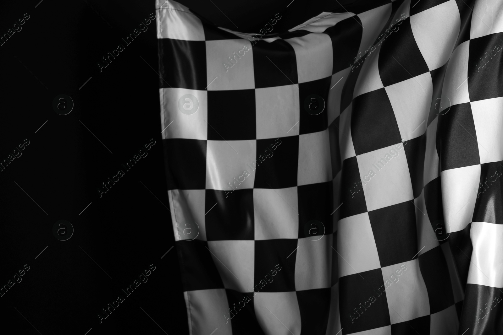 Photo of One racing checkered flag on black background, space for text