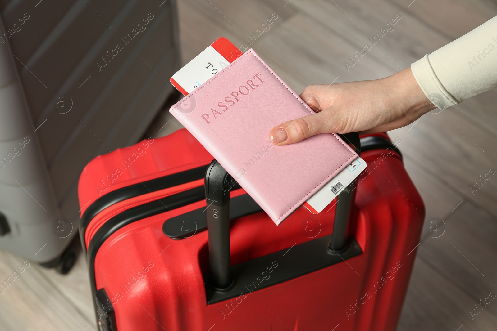 Photo of Woman with passport, ticket and suitcases indoors, closeup