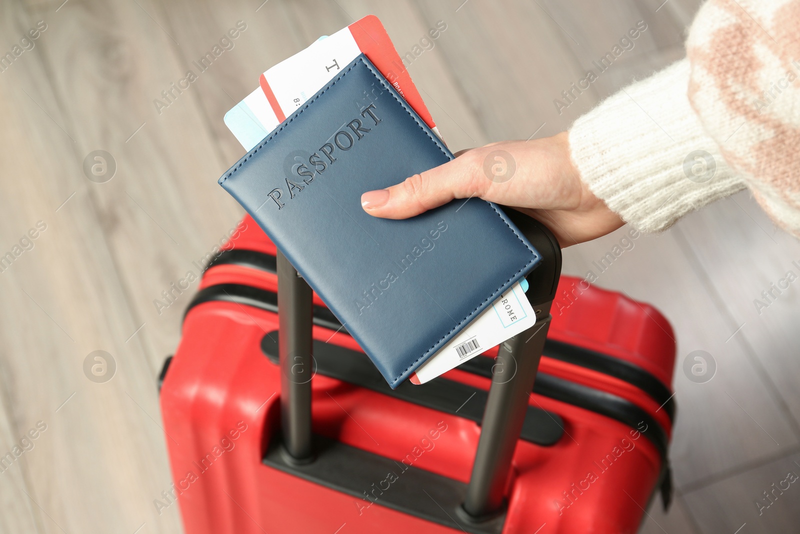 Photo of Woman with passport, tickets and suitcase indoors, closeup