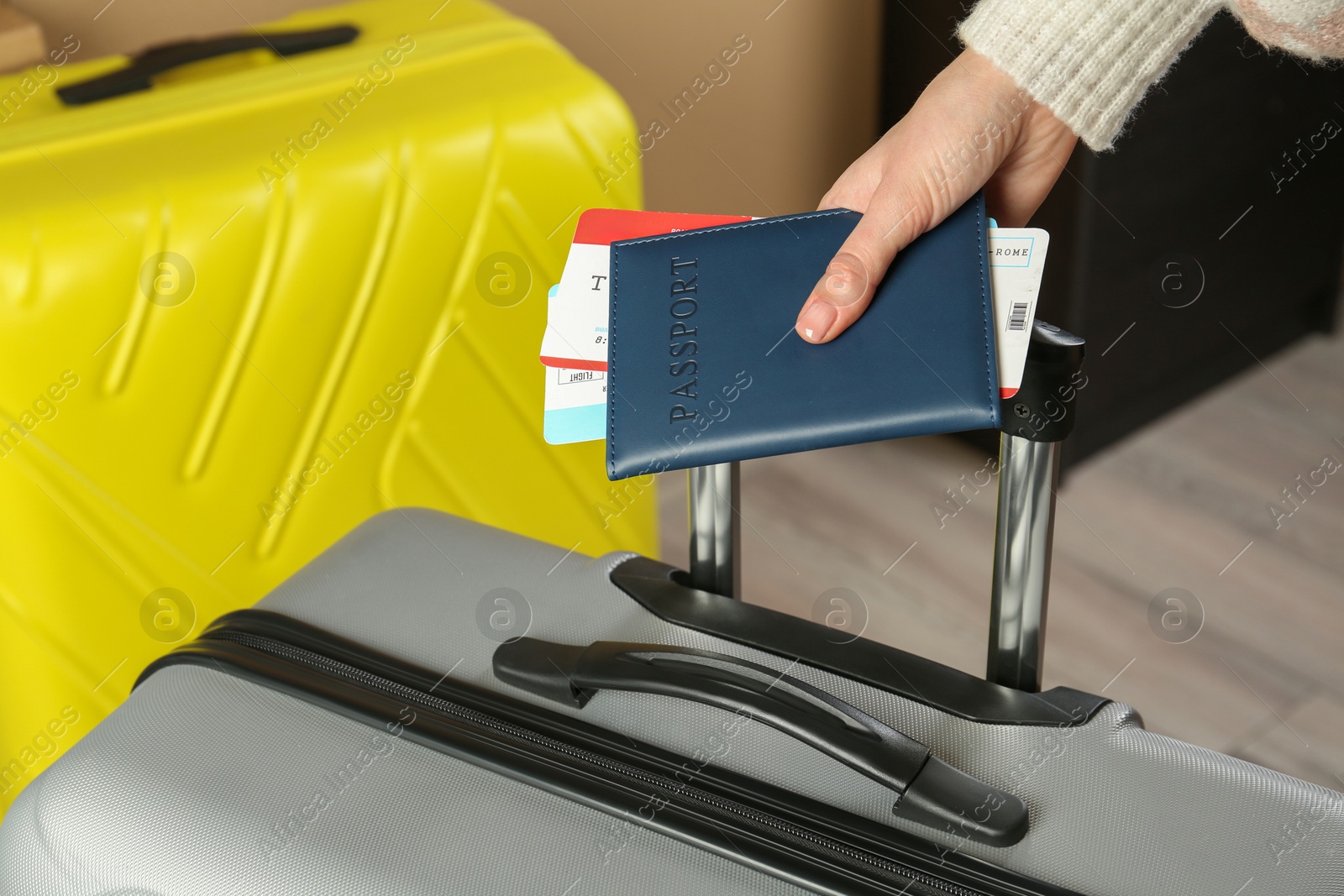 Photo of Woman with passport, tickets and suitcases indoors, closeup