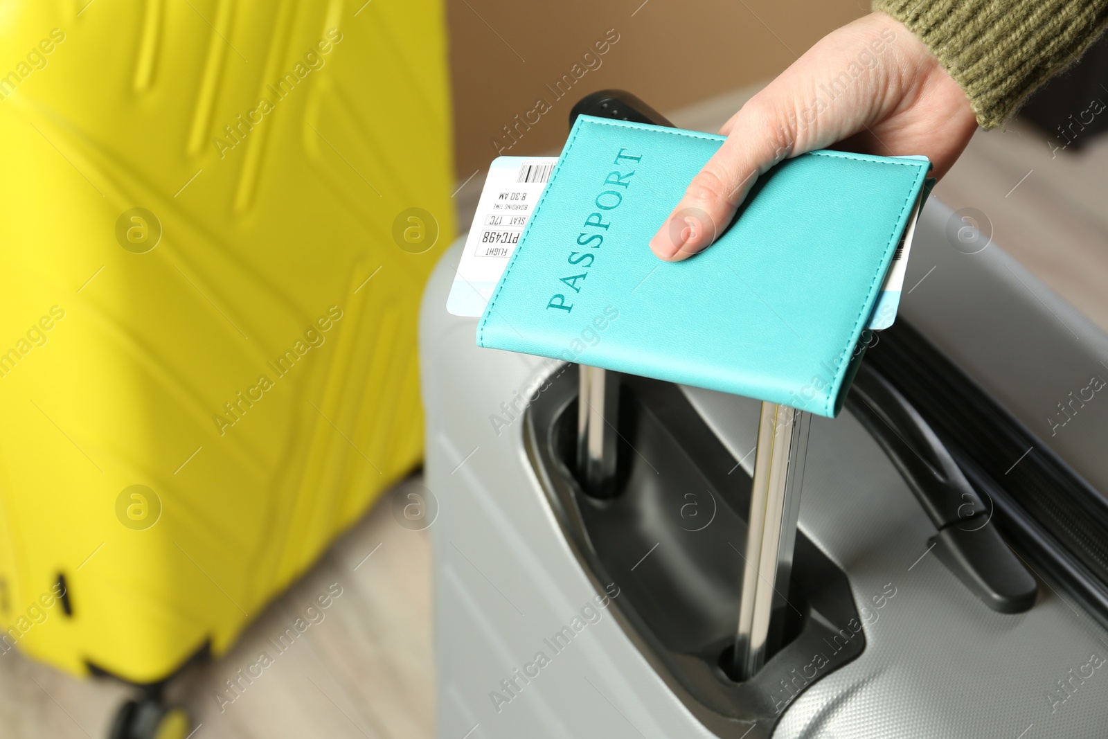 Photo of Woman with passport, ticket and suitcases indoors, closeup