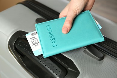 Photo of Woman with passport, ticket and suitcase indoors, closeup