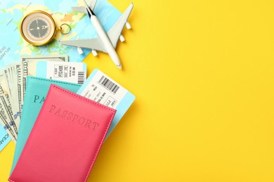 Photo of Passports with tickets, map, money, compass and airplane model on yellow background, flat lay. Space for text